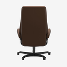 A high-back brown upholstered office chair with a black five-star wheeled base, shown from the rear on a light gray background.