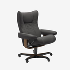 A dark gray upholstered office chair with a high back, padded armrests, and a five-star black base with wood-toned accents, shown on a light gray background.